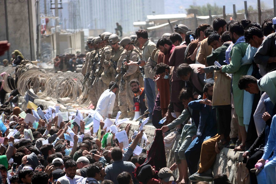 epaselect epa09430526 Afghans struggle to reach the foreign forces to show their credentials to flee the country outside the Hamid Karzai International Airport, in Kabul, Afghanistan, 26 August 2021. At least 13 people including children were killed in a blast outside the airport on 26 August. The blast occurred outside the Abbey Gate and follows recent security warnings of attacks ahead of the 31 August deadline for US troops withdrawal.  EPA/AKHTER GULFAM