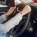 Lady in a car salon. Woman buying the car. Blonde in a white shirt