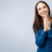 Portrait of happy gesturing smiling young woman in casual smart blue clothing, with copyspace for slogan or text message