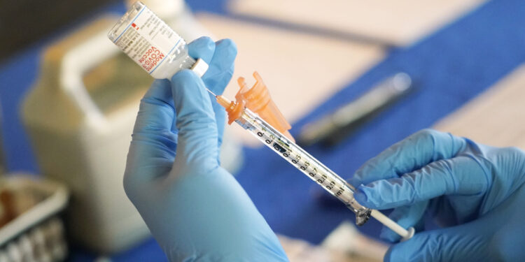 FILE - A nurse prepares a syringe of a COVID-19 vaccine at an inoculation station in Jackson, Miss., Tuesday, July 19, 2022. On Thursday, Oct. 20, 2022, a panel of U.S. vaccine experts said COVID-19 shots should be added to the lists of recommended vaccinations for kids and adults. (AP Photo/Rogelio V. Solis, File)