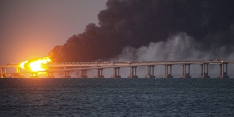 FILE - Flame and smoke rise fron Crimean Bridge connecting Russian mainland and Crimean peninsula over the Kerch Strait, in Kerch, Crimea, Saturday, Oct. 8, 2022. The Crimean Peninsula's balmy beaches have been vacation spots for Russian czars and has hosted history-shaking meetings of world leaders. And it has been the site of ethnic persecutions, forced deportations and political repression. Now, as Russia’s war in Ukraine enters its 18th month, the Black Sea peninsula is again both a playground and a battleground. (AP Photo, File)